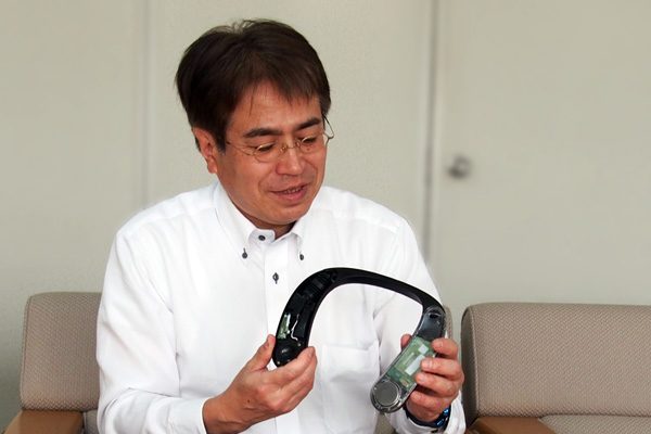ネックスピーカー試作機を持つ開発担当の蓑田さん