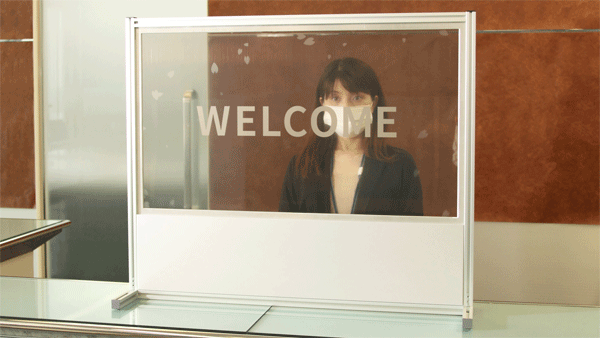 「透明ディスプレイ パーティション」 受付での使用シーン<br/>（状況に応じてディスプレイを透明にしたり白表示にしたりできます）